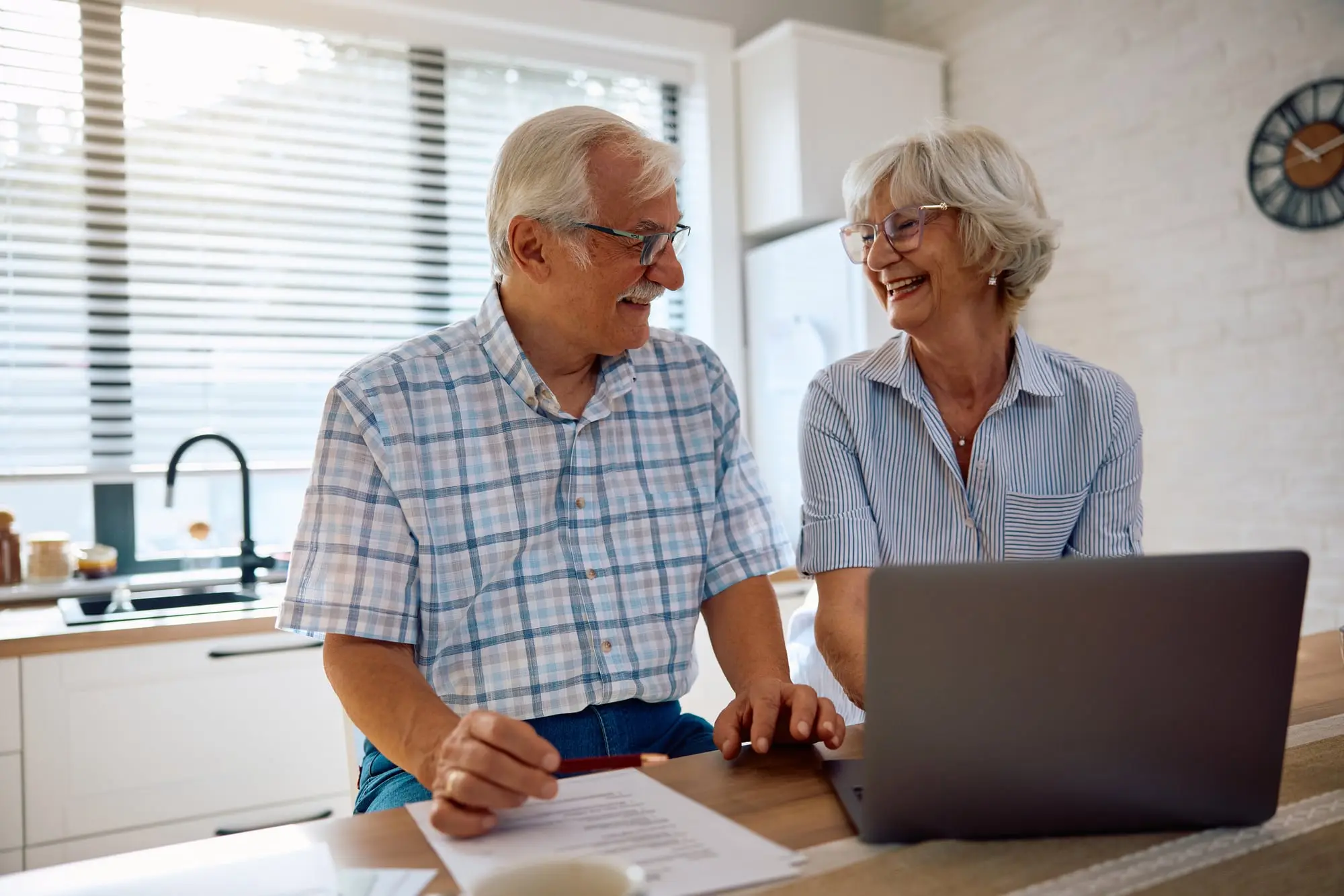 A retired couple going over their finances together at the kitchen counter
