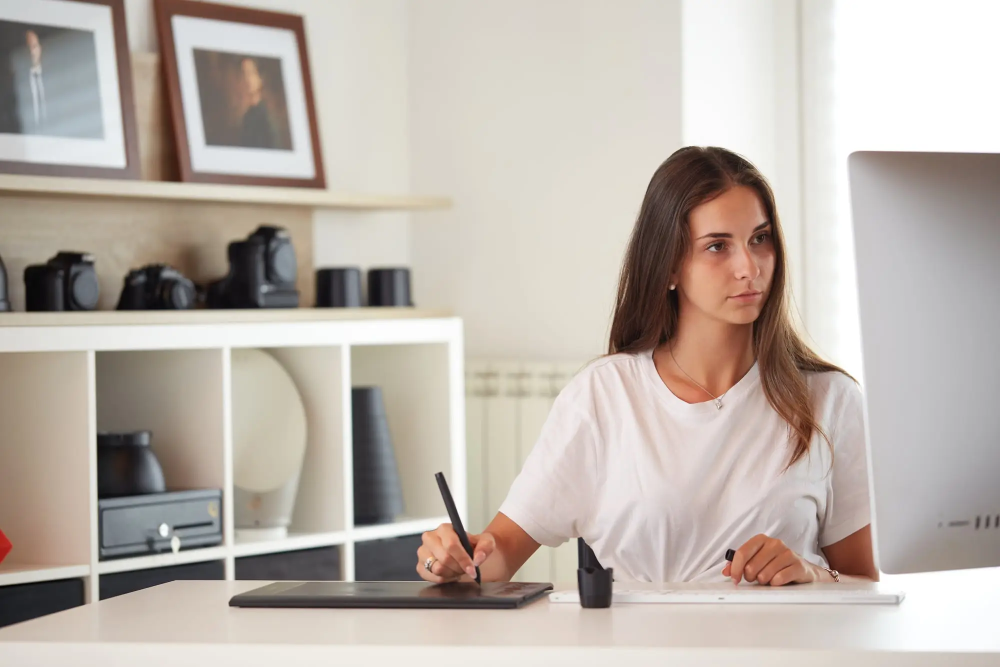 A designer sketching on a drawing tablet in her home studio