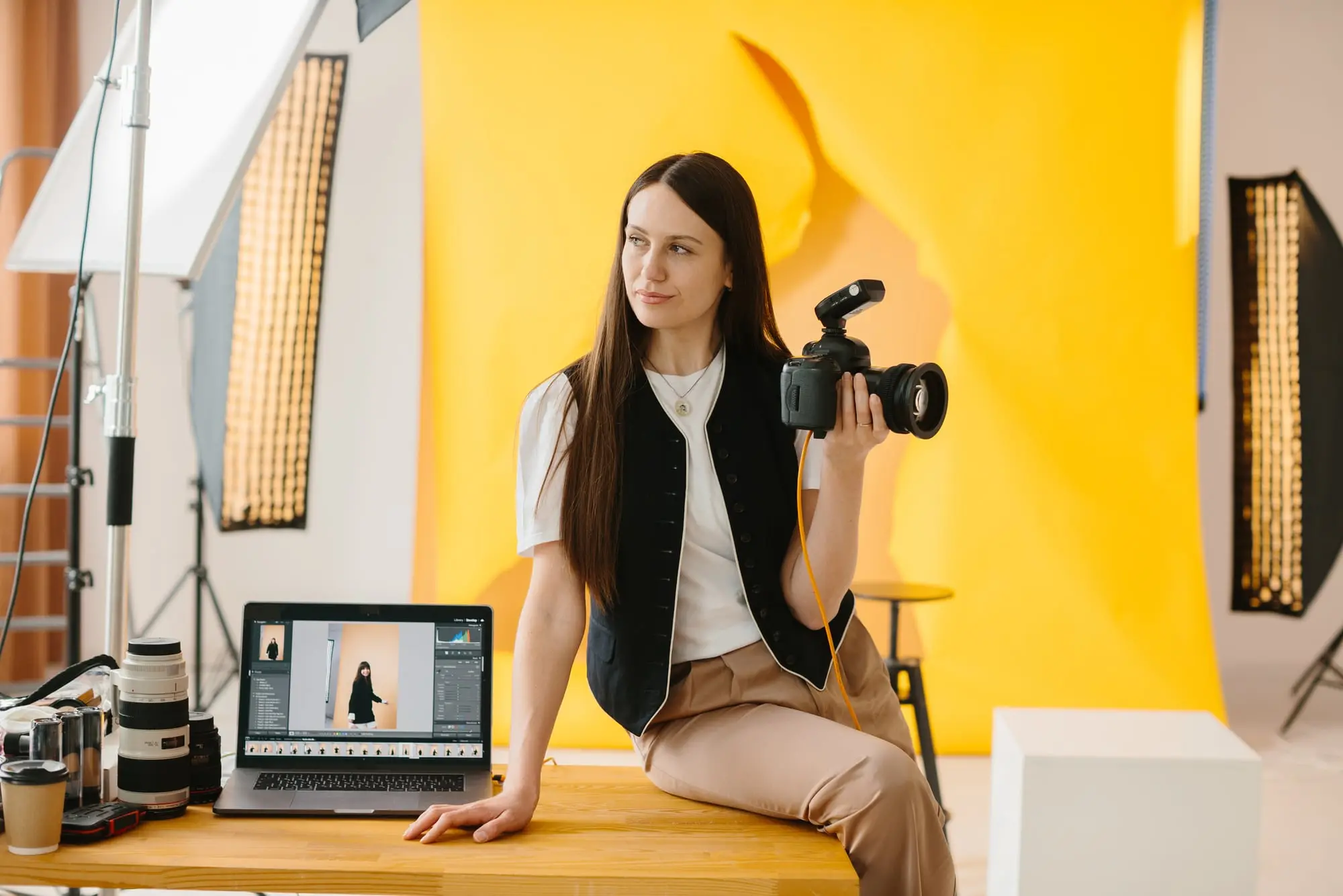 A photographer in her studio holding her camera