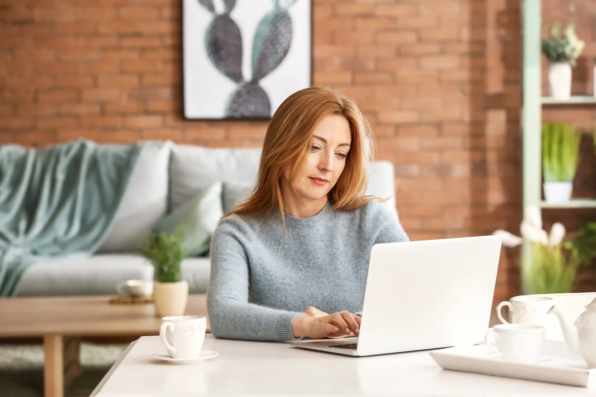 A woman working on her laptop in her living room